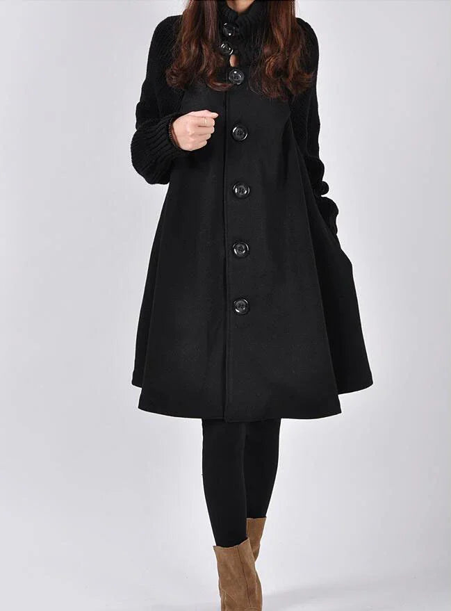 Woman wearing a black buttoned wool coat with knit sleeves and brown suede ankle boots