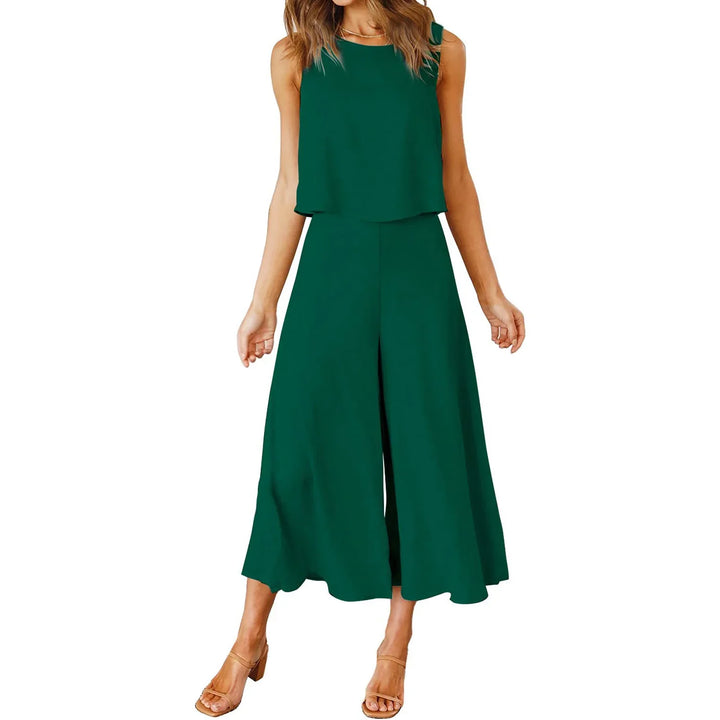 Woman wearing sleeveless dark green jumpsuit with wide-leg cropped pants and beige heels