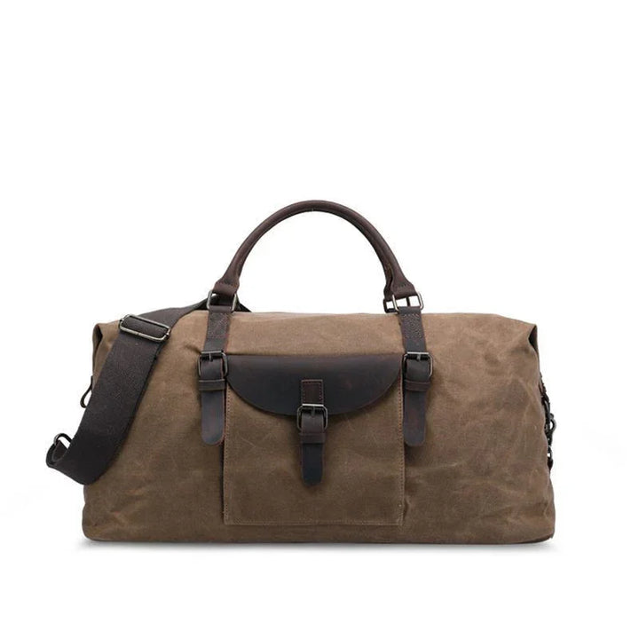 Brown canvas duffel bag with leather straps and front buckle pocket, adjustable shoulder strap
