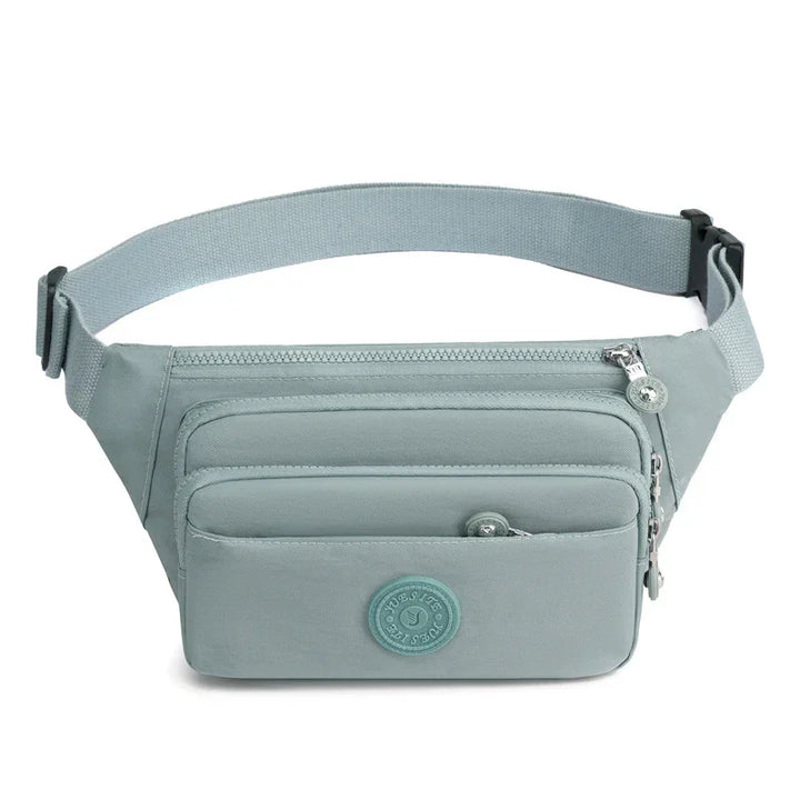 Light blue fabric waist bag with three zippered compartments and adjustable strap