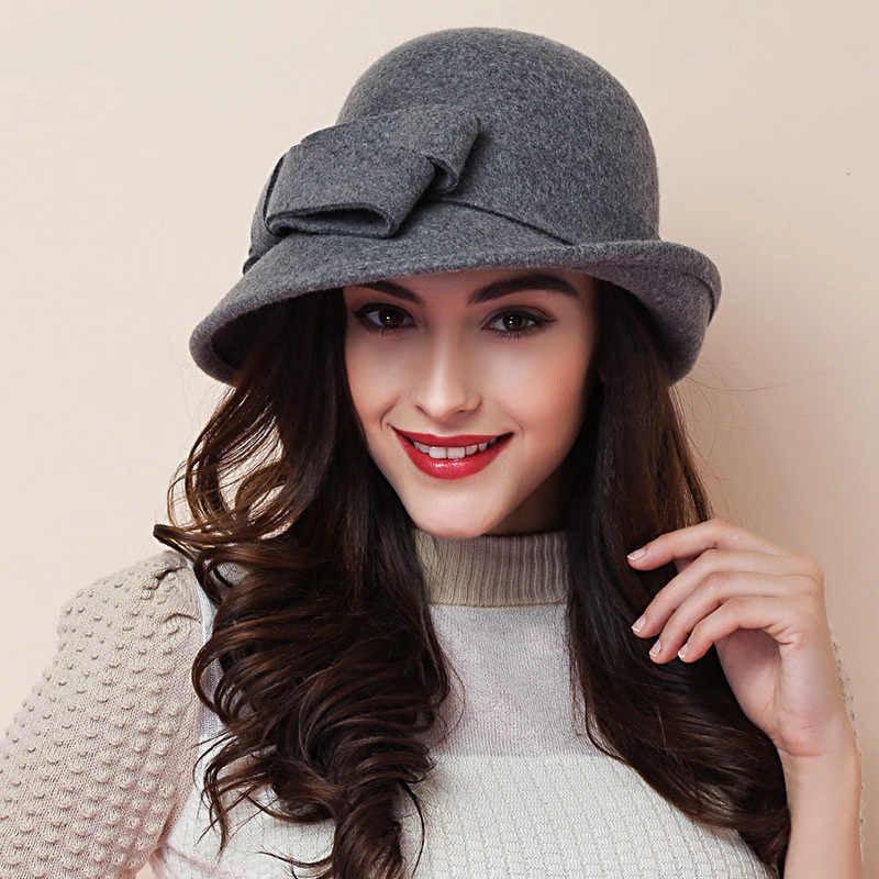 Woman wearing a stylish gray felt hat with bow detail and a beige textured sweater, smiling