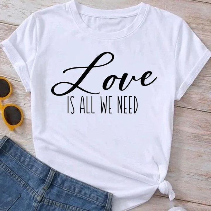White t-shirt with black text Love is all we need, paired with blue denim jeans and yellow sunglasses
