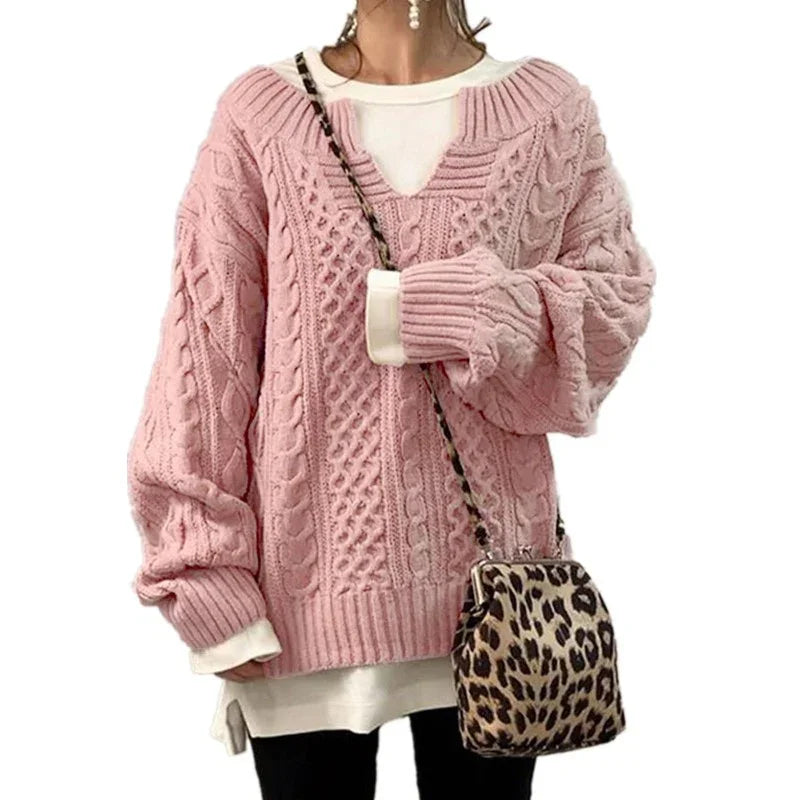 Woman wearing oversized pink cable knit sweater with white undershirt paired with leopard print crossbody bag