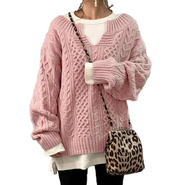 Woman wearing oversized pink cable knit sweater with white undershirt paired with leopard print crossbody bag
