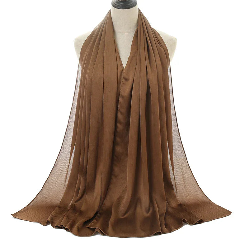 Elegant brown pleated chiffon scarf draped on white mannequin torso