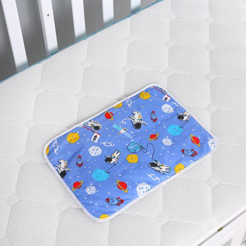Blue space-themed baby changing pad with astronauts, rockets, planets on white crib mattress