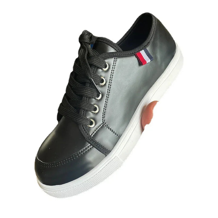 Black leather sneaker with white rubber sole and red, white, and blue fabric detail on side