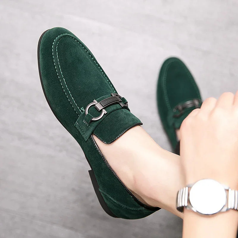 Close-up of elegant green suede loafers with silver buckle detail worn on feet