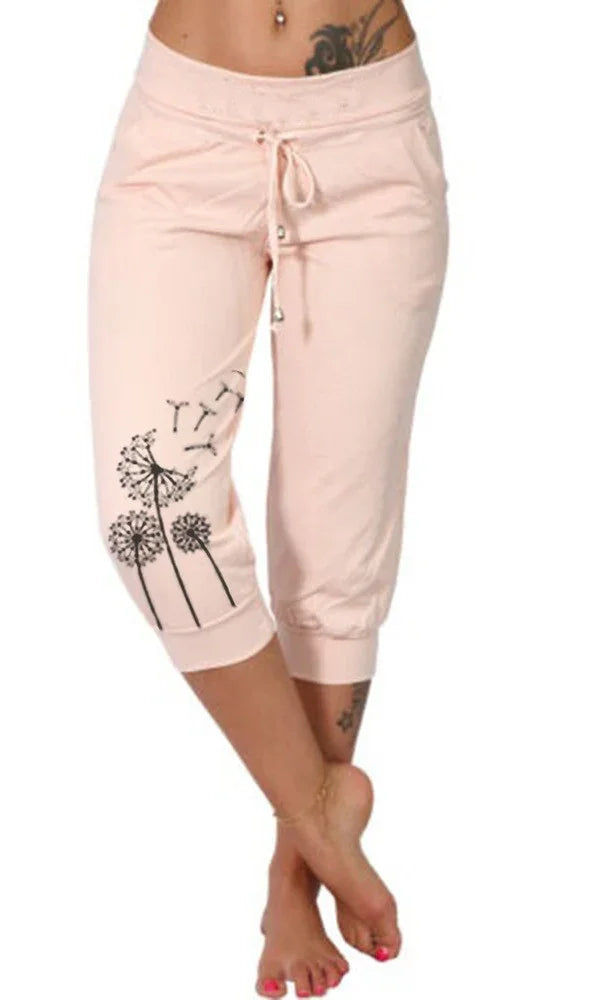 Woman wearing light pink capri pants with black dandelion print and drawstring waist