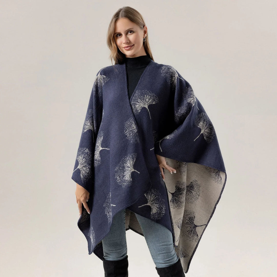Woman wearing navy blue floral print wrap shawl poncho over black turtleneck and jeans