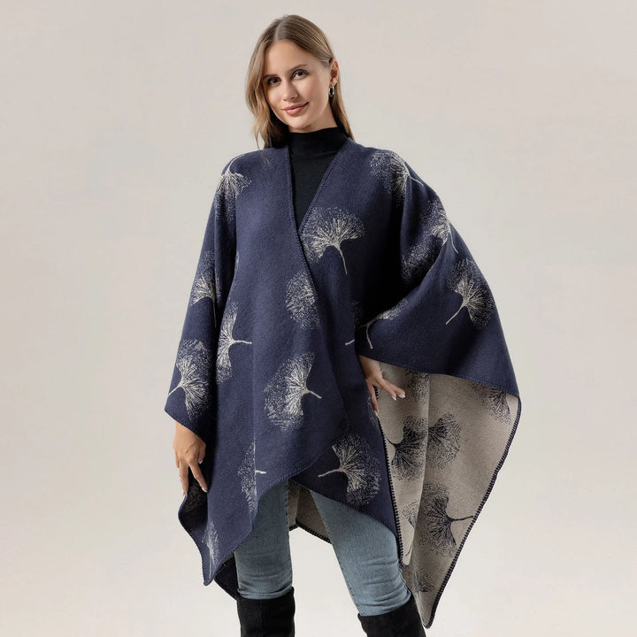 Woman wearing navy blue floral print wrap shawl poncho over black turtleneck and jeans