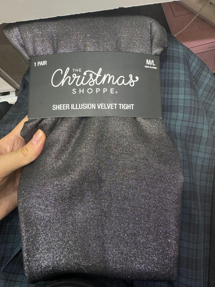 Hand holding black sheer illusion velvet tights packaging from The Christmas Shoppe in size M/L