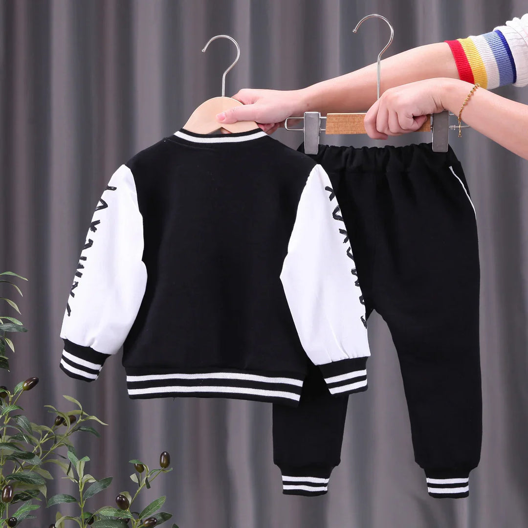 Black and white kids' two-piece casual outfit with striped cuffs and graphic sleeves on hangers