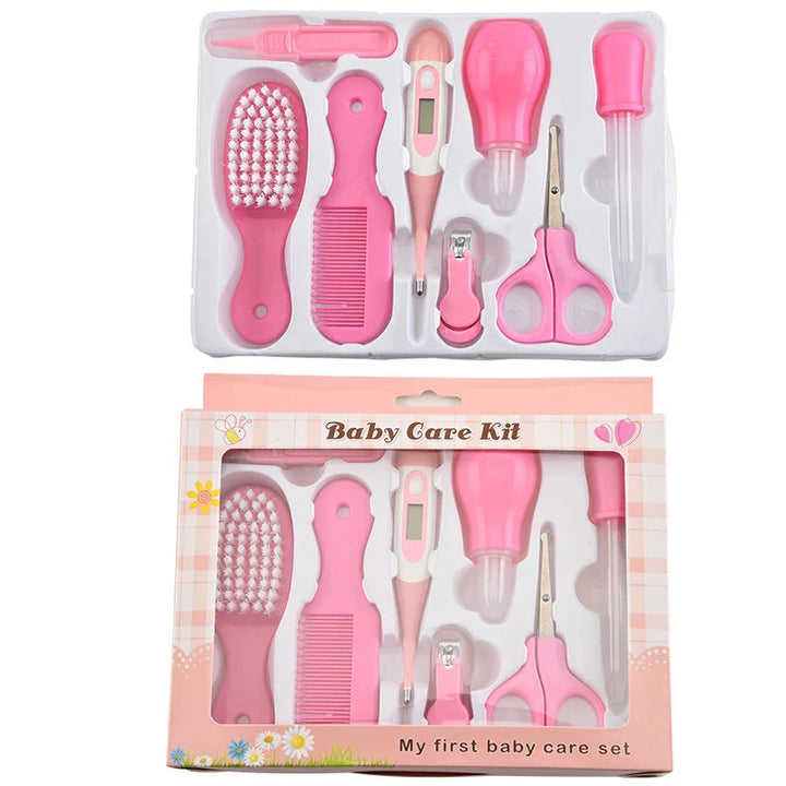 Pink baby care kit with brush, comb, digital thermometer, nail clippers, scissors, and dropper in packaging