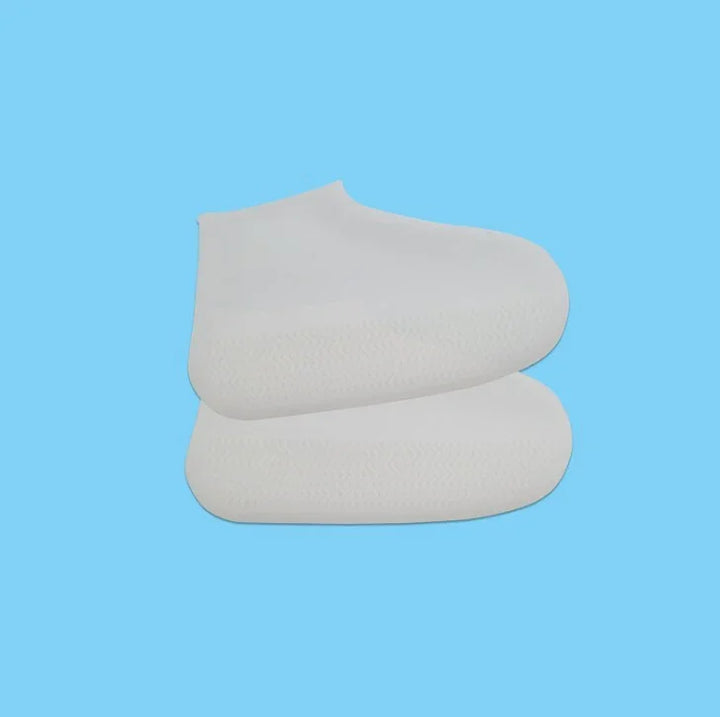 Pair of white silicone shoe covers on blue background, water-resistant and protective footwear accessories
