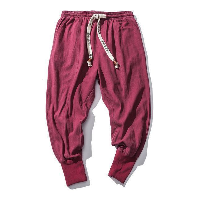 Maroon casual jogger pants with elastic waistband and white drawstring on white background