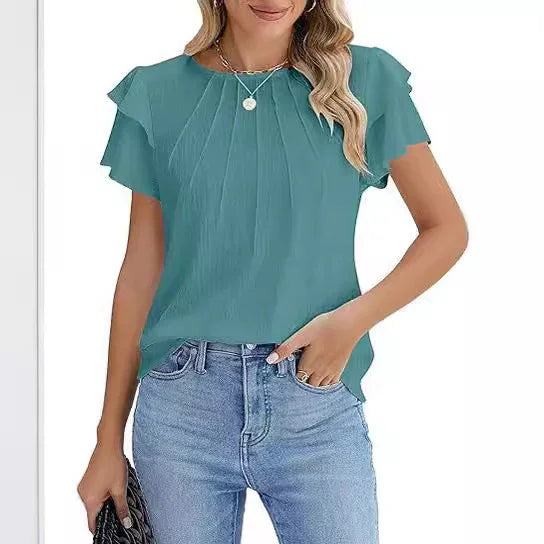 woman wearing teal short-sleeve pleated blouse with ruffle detail and light blue jeans