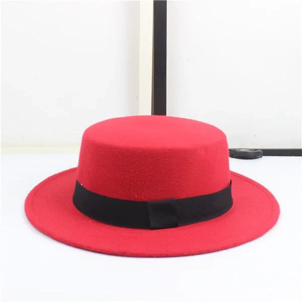 Red wool fedora hat with wide brim and black band on white background