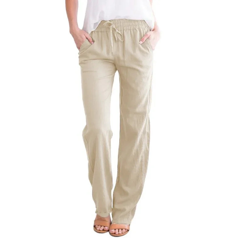 Woman wearing beige wide-leg drawstring pants with pockets and sandals