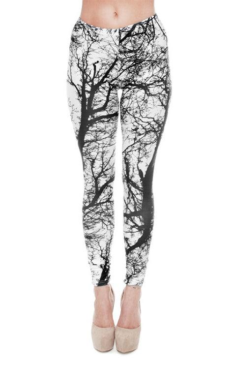 Women's leggings with black and white leafless tree branch pattern, worn with beige heels