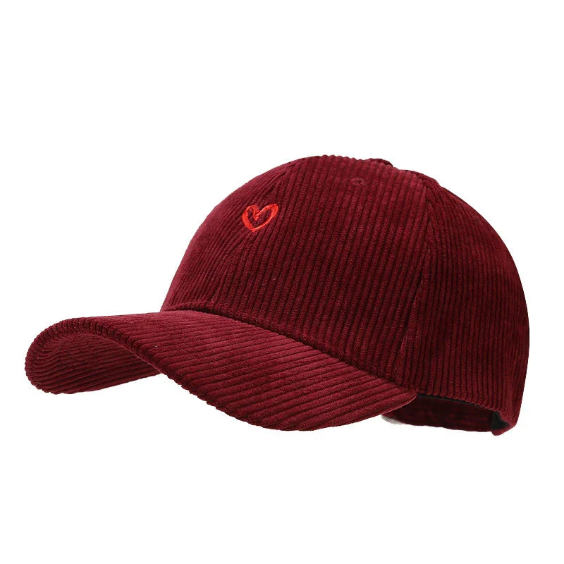 Burgundy corduroy baseball cap with small red embroidered heart on front, adjustable back strap