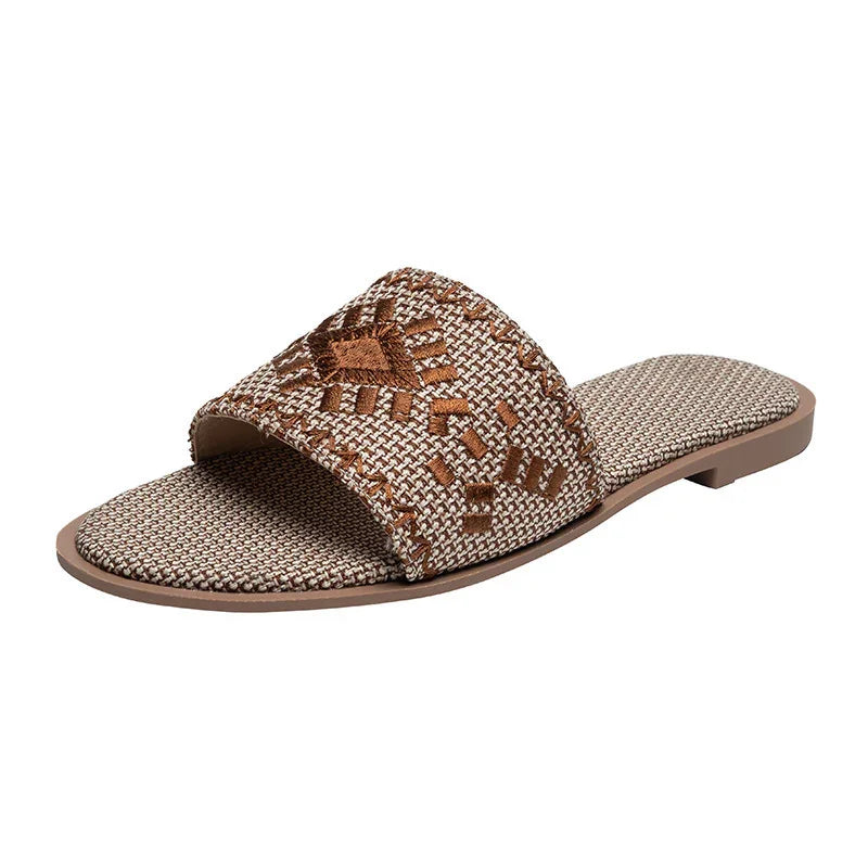 Beige and brown woven slide sandal with intricate embroidered geometric pattern