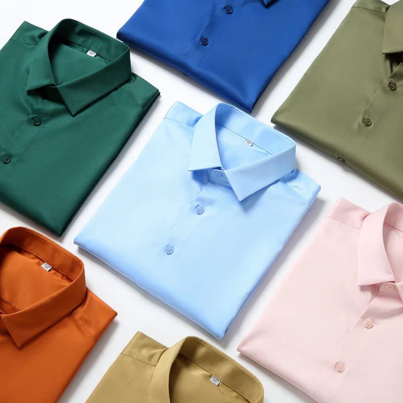 Folded men's solid color dress shirts in blue, green, orange, pink, olive, and beige on white background