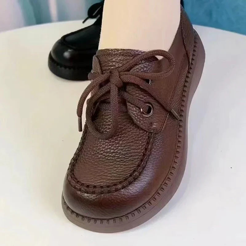 Close-up of brown leather loafer shoe with thick sole and lace-up design on white surface