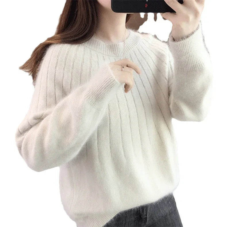 Woman wearing a soft white ribbed knit sweater, taking a mirror selfie