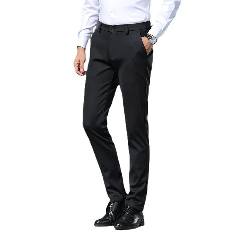 Man wearing black formal trousers paired with black dress shoes and a white shirt against white background