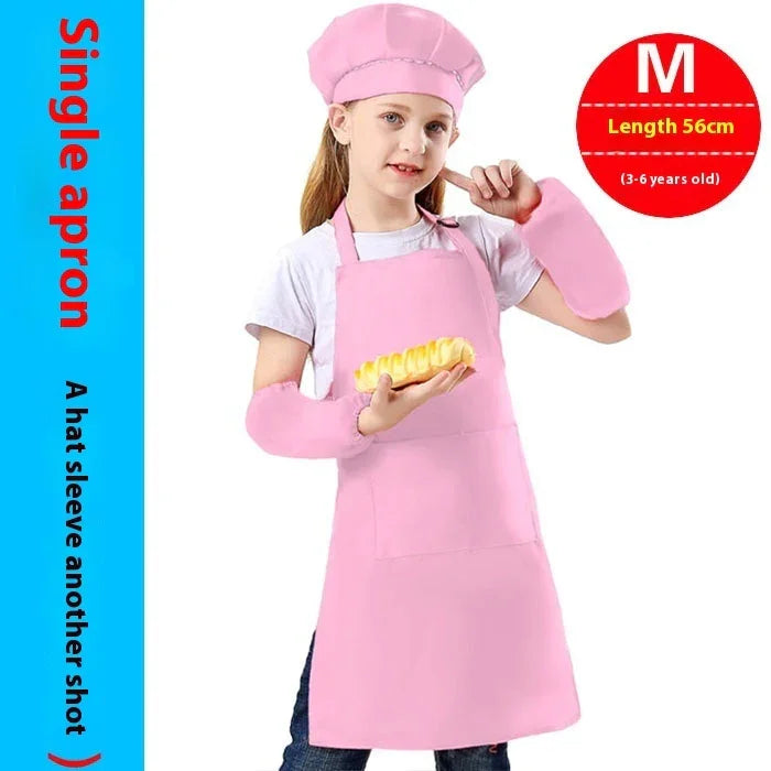 Young girl wearing pink chef apron, matching hat and arm sleeves, holding pastry, cooking outfit for kids