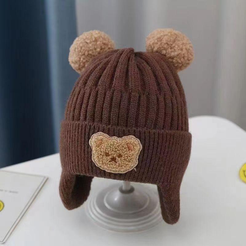 Brown knitted children's winter hat with bear ears and a crocheted bear patch