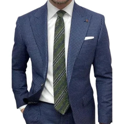 Man wearing blue checkered suit with white shirt and green striped tie, pocket square visible