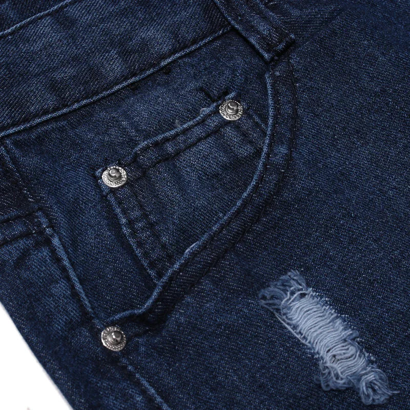 Dark blue denim jeans close-up showing front pocket with rivets and distressed fabric detail