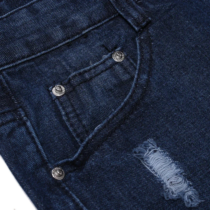 Dark blue denim jeans close-up showing front pocket with rivets and distressed fabric detail