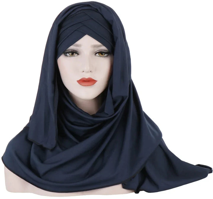 female mannequin wearing a navy blue layered hijab scarf with draped fabric on white background