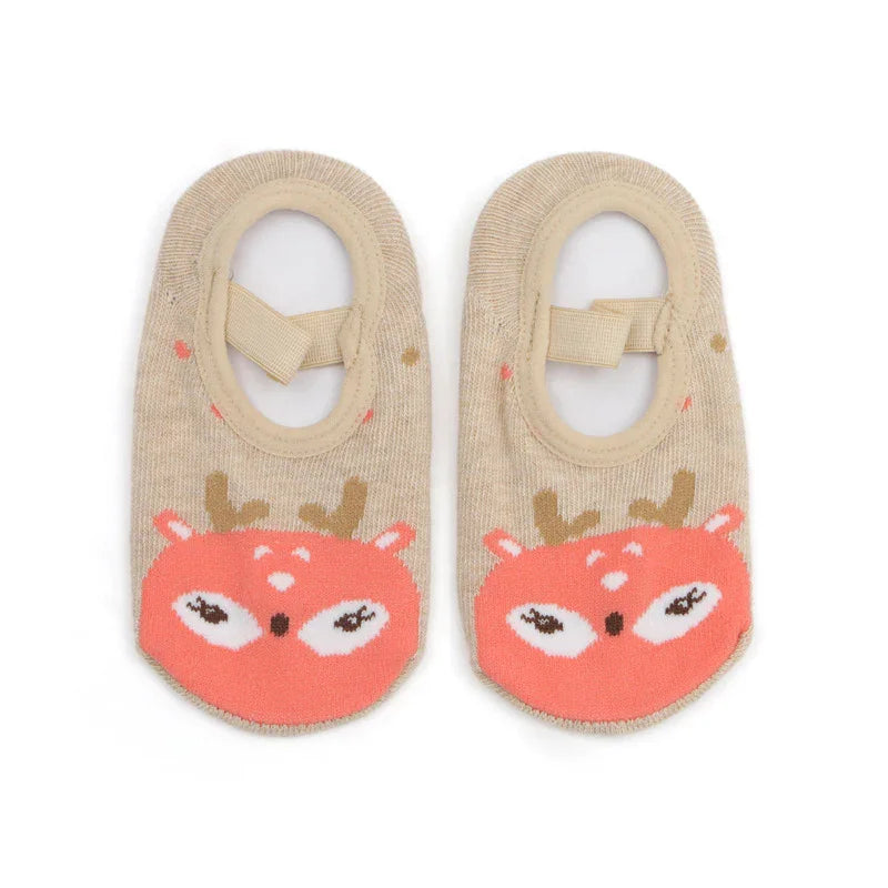 Pair of beige baby socks with pink deer face design and ankle straps on white background