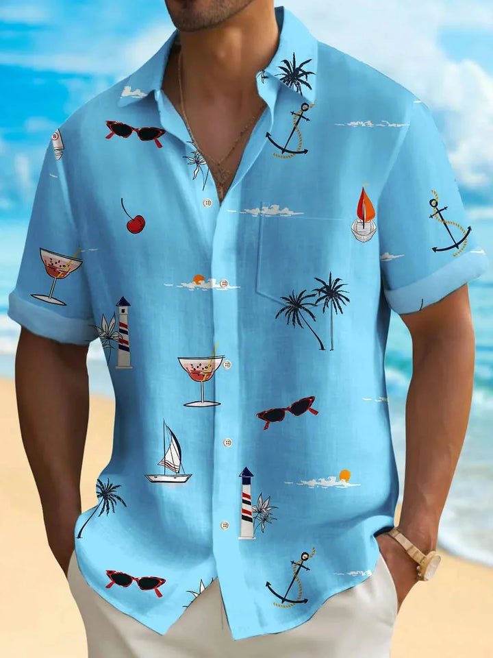 Man wearing light blue tropical beach shirt with palm trees, anchors, sailboats, cocktails, sunglasses