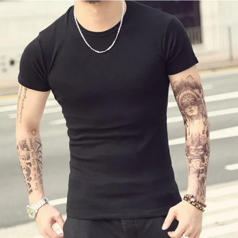 Man wearing black fitted t-shirt, silver chain, wristwatch, and bracelets with full arm tattoos outdoors