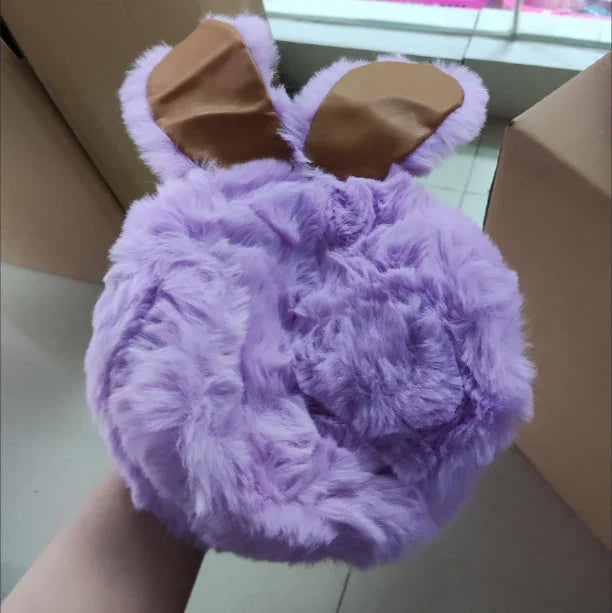 Hand holding a fluffy purple round object with bunny ears made of faux leather on top