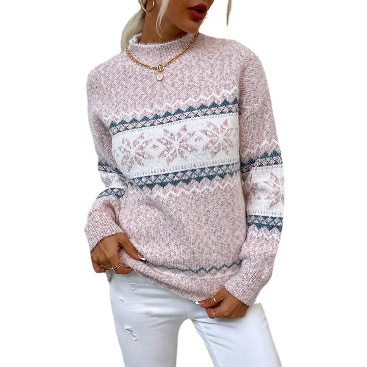 Woman wearing pink and white Nordic pattern knit sweater with gold jewelry and white pants