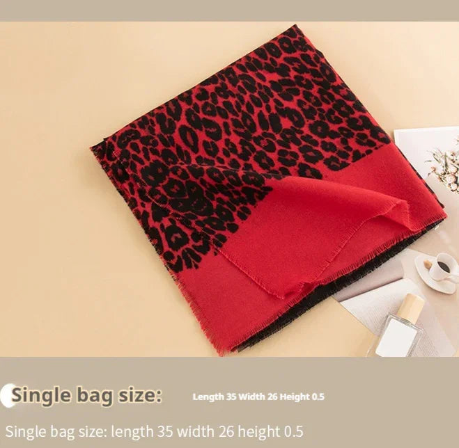 Red and black leopard print scarf with solid red edge on beige background