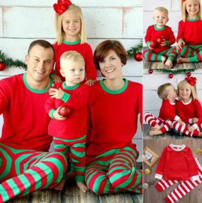 Family of four in matching red and green Christmas pajamas posing with holiday decor
