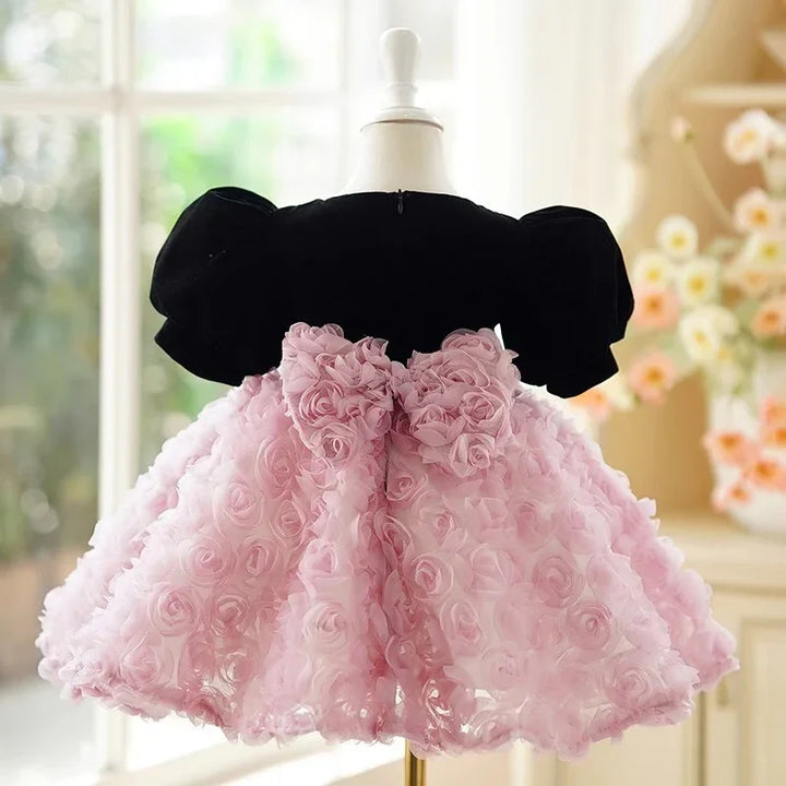 Elegant baby dress with black velvet puff sleeves and pink floral rose skirt on mannequin