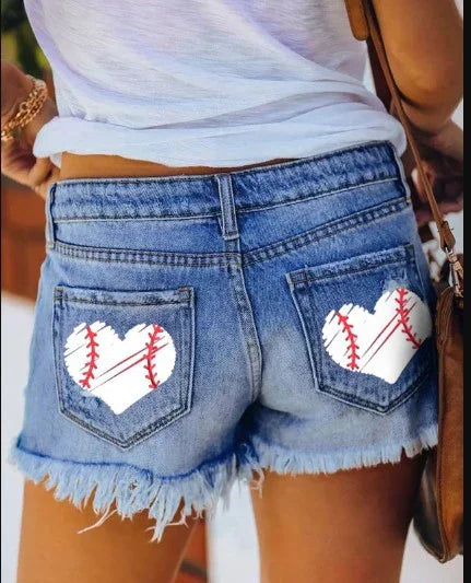 Back view of denim shorts with frayed edges and white heart-shaped baseball stitching patches on back pockets