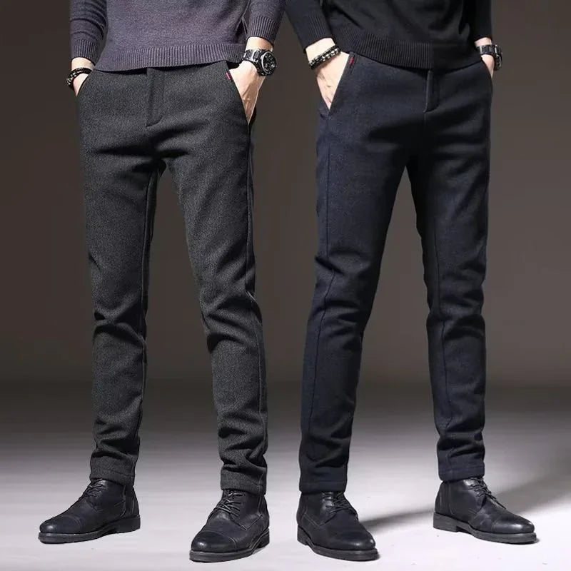 Two men wearing slim fit dark gray and navy trousers with black leather shoes and sweaters in studio