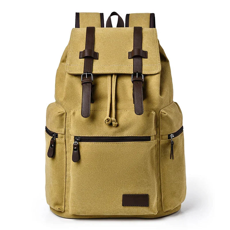 Khaki canvas backpack with brown leather straps, front zipper pocket, and side zip pockets