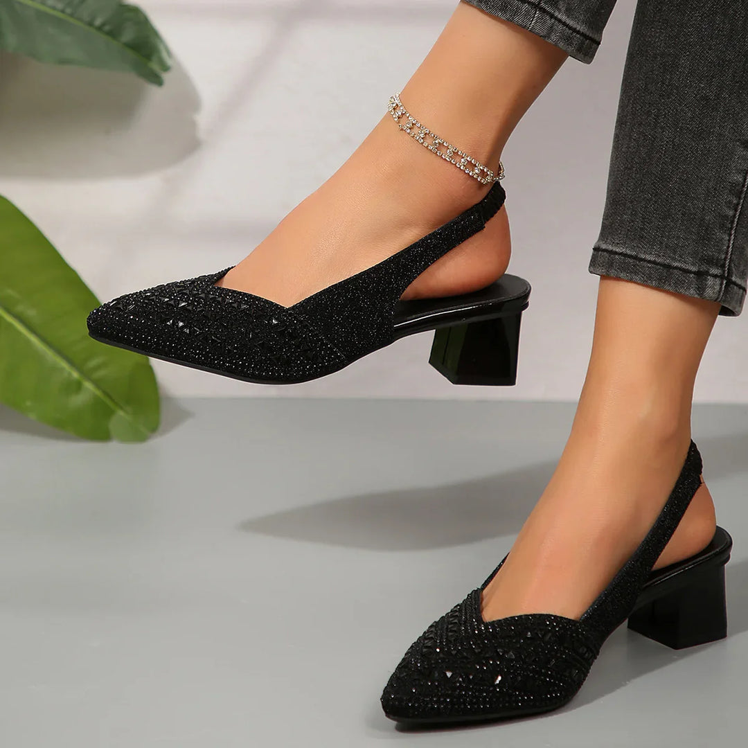 Black slingback block heel shoes with sparkling embellishments worn with dark jeans and rhinestone anklet