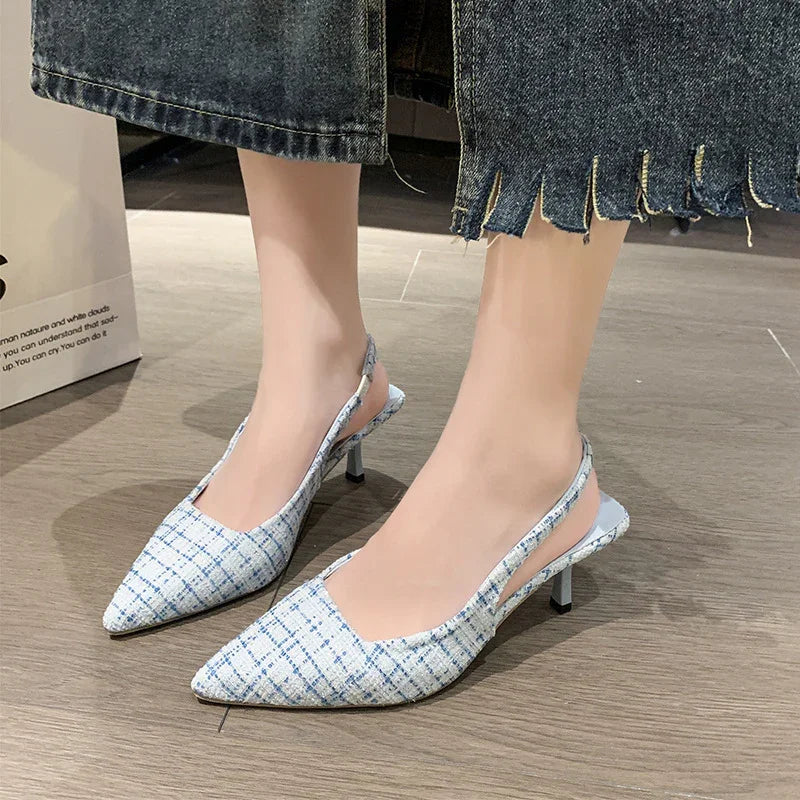 Woman wearing blue and white plaid slingback kitten heel shoes with frayed denim jeans