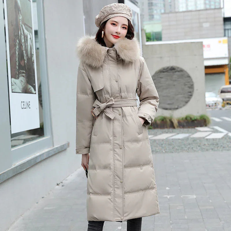 Woman in beige long padded coat with fur collar and matching beret on urban street